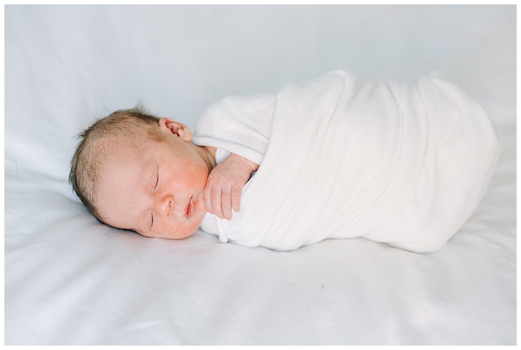 newborn swaddled in white 