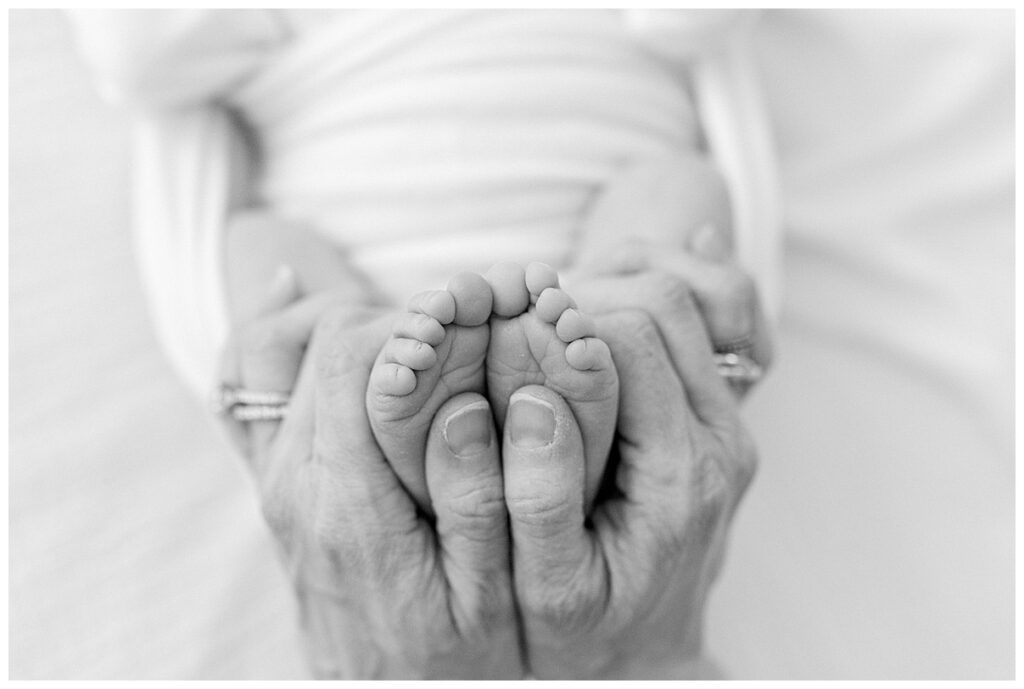 mother's hands around newborn toes