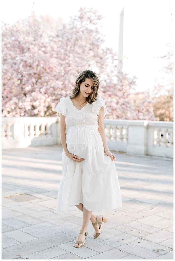 maternity photos with white dress and pink blossoms and Washington Monument 