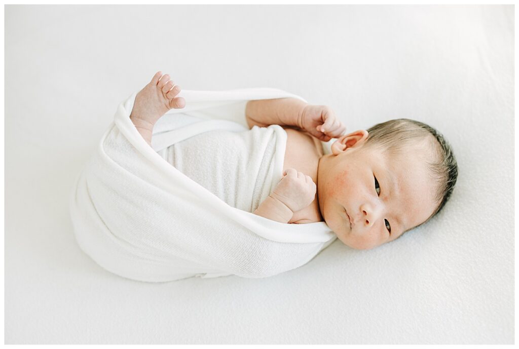 baby swaddled in white wrap 