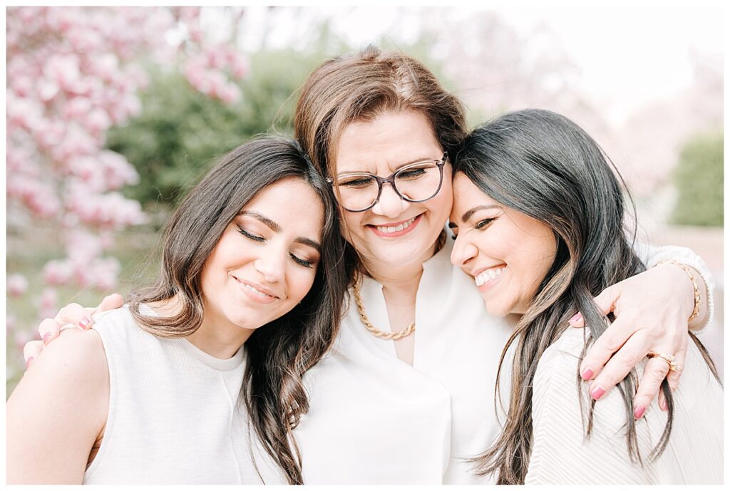 mother with two grown daughters hugging 