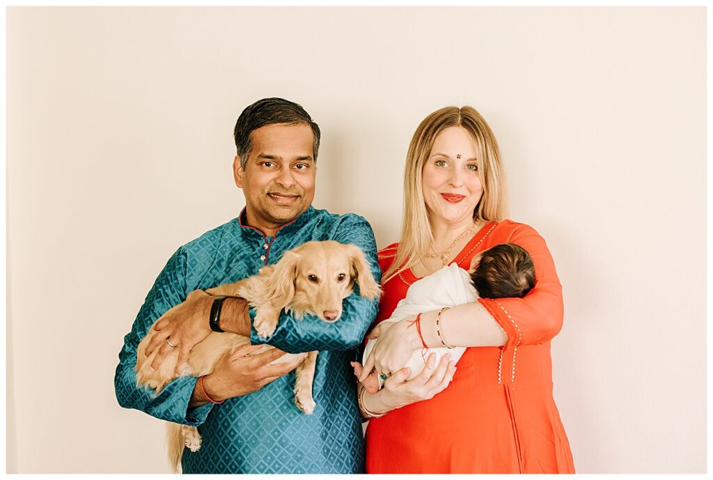 parents with newborn girl and dog 