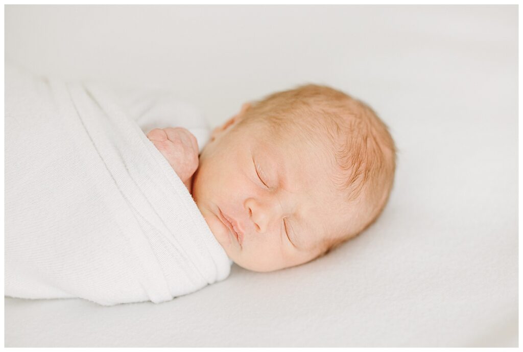 newborn baby sleeping in wrapped swaddle 