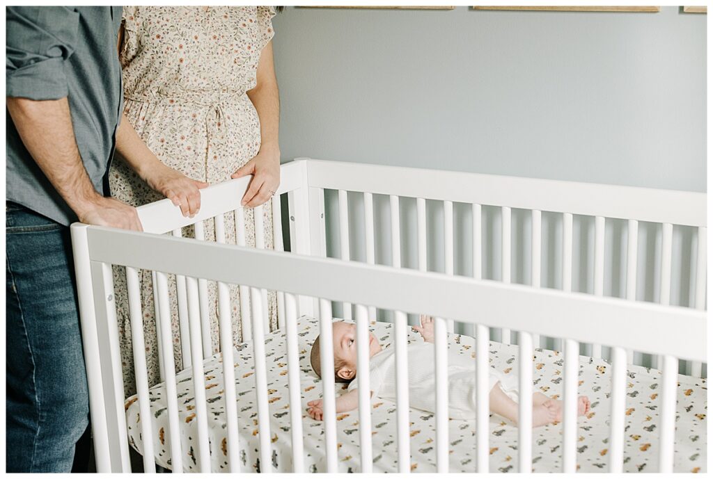 baby boy laying in crib in nursery 