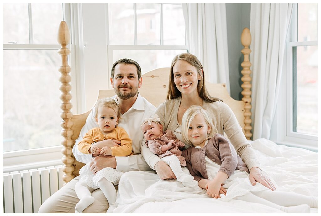 family of five sitting on a bed 