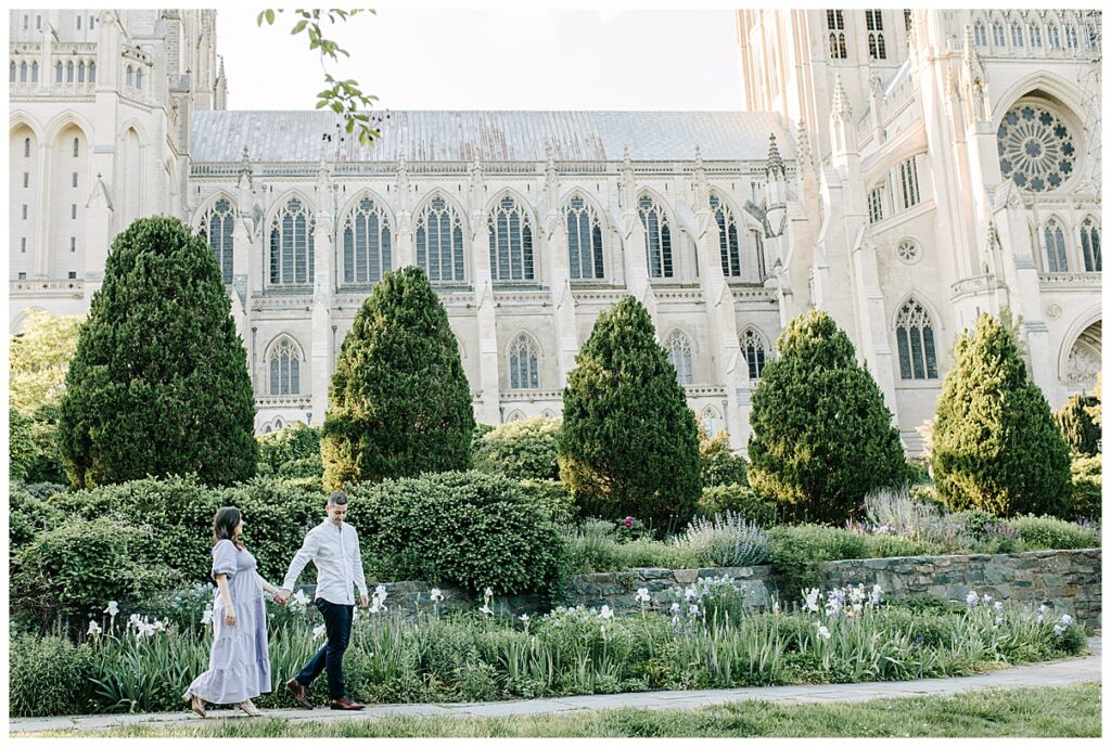 expecting couple walking in front of cathedral 