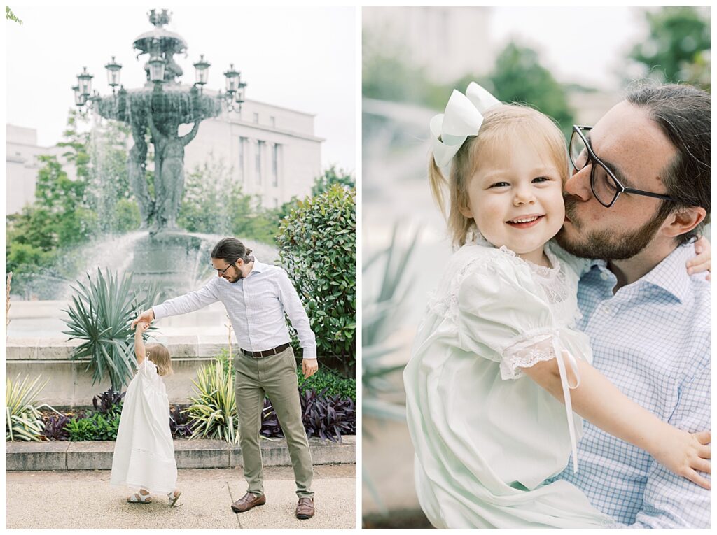 dad twirling his little girl in front of a fountain 