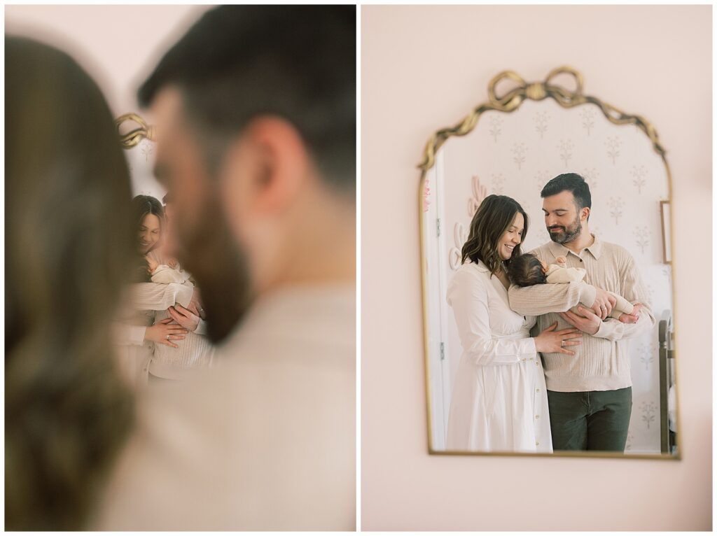 parents holding baby in a mirror