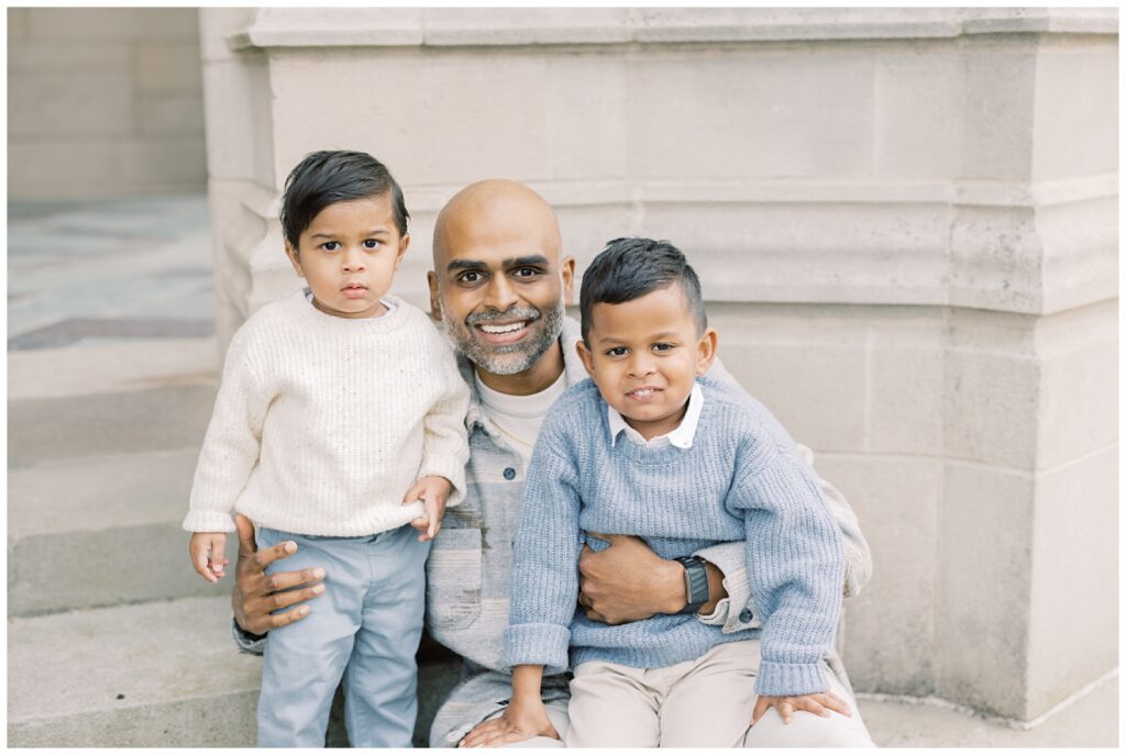father holding two young boys 